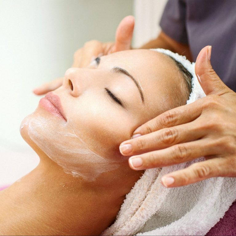 Woman receiving a facial massage from a specialist.