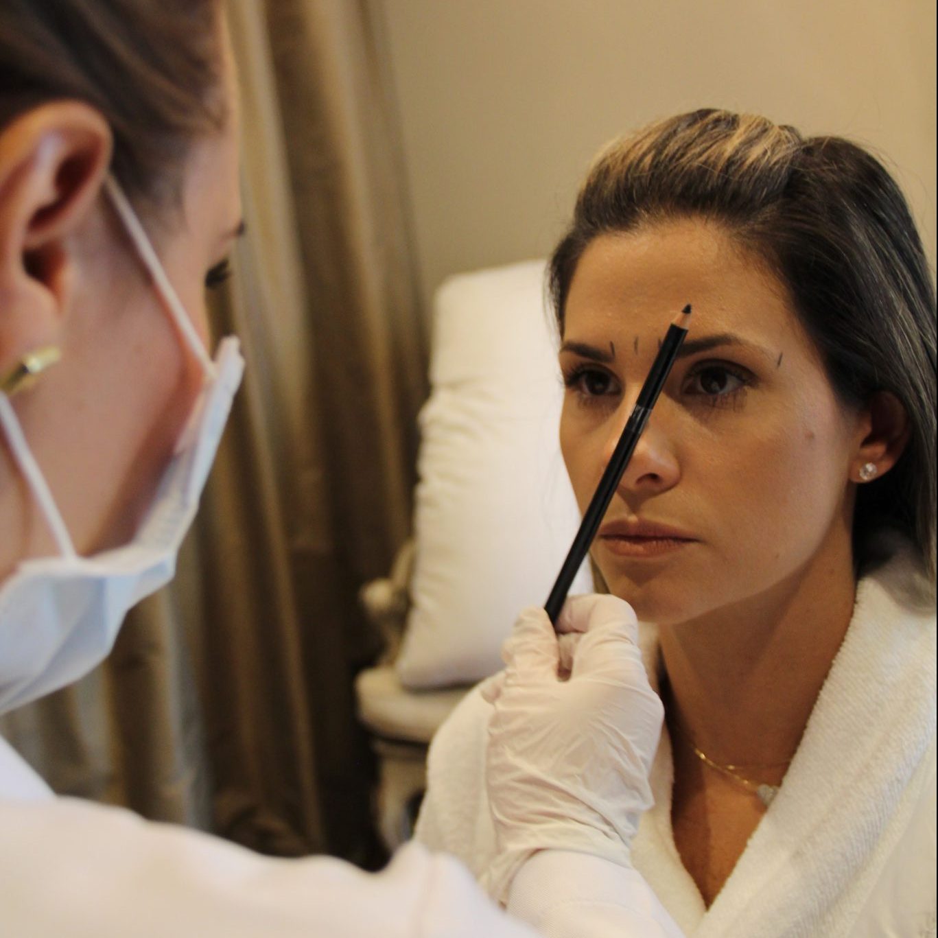 Woman receiving cosmetic facial work from a specialist.