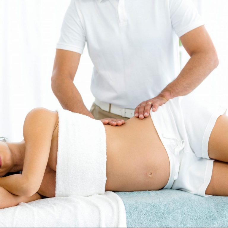 Therapist providing a woman with a tender postpartum massage.