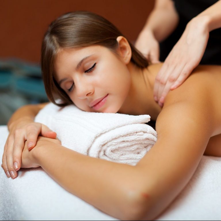 Woman experiencing a popular Swedish massage from a massage therapist.